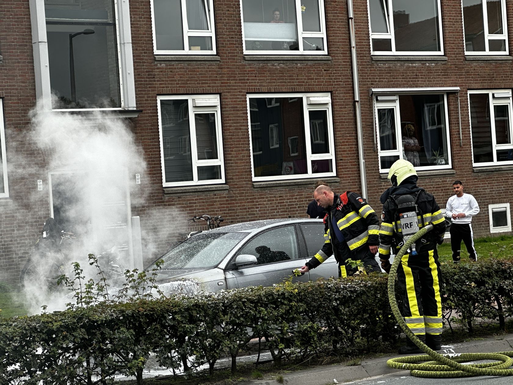 Brandweer blust brand in motorcompartiment van auto in Leeuwarden