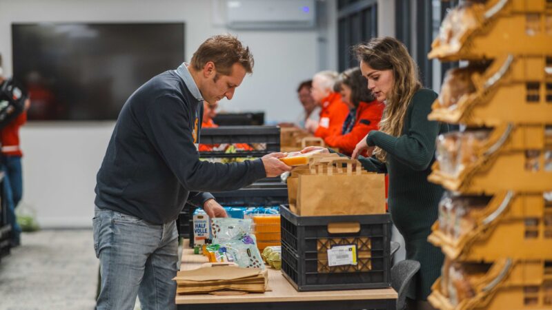 Wethouder Hein Kuiken helpt het Rode Kruis met inpakken van ontbijttassen