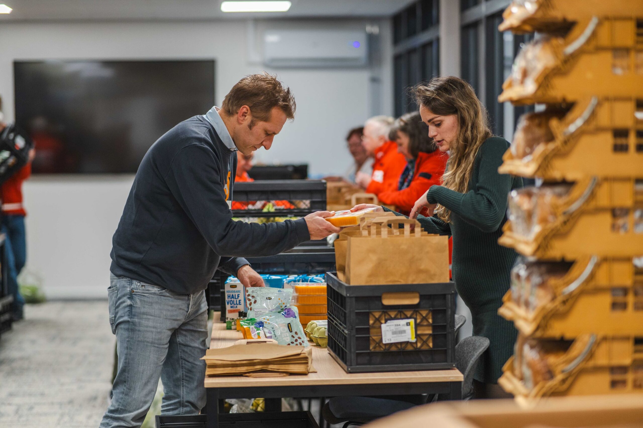 Wethouder Hein Kuiken helpt het Rode Kruis met inpakken van ontbijttassen