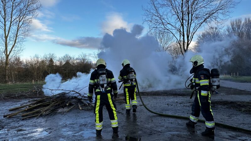 Brandweer blust brand in een berg takken te Leeuwarden