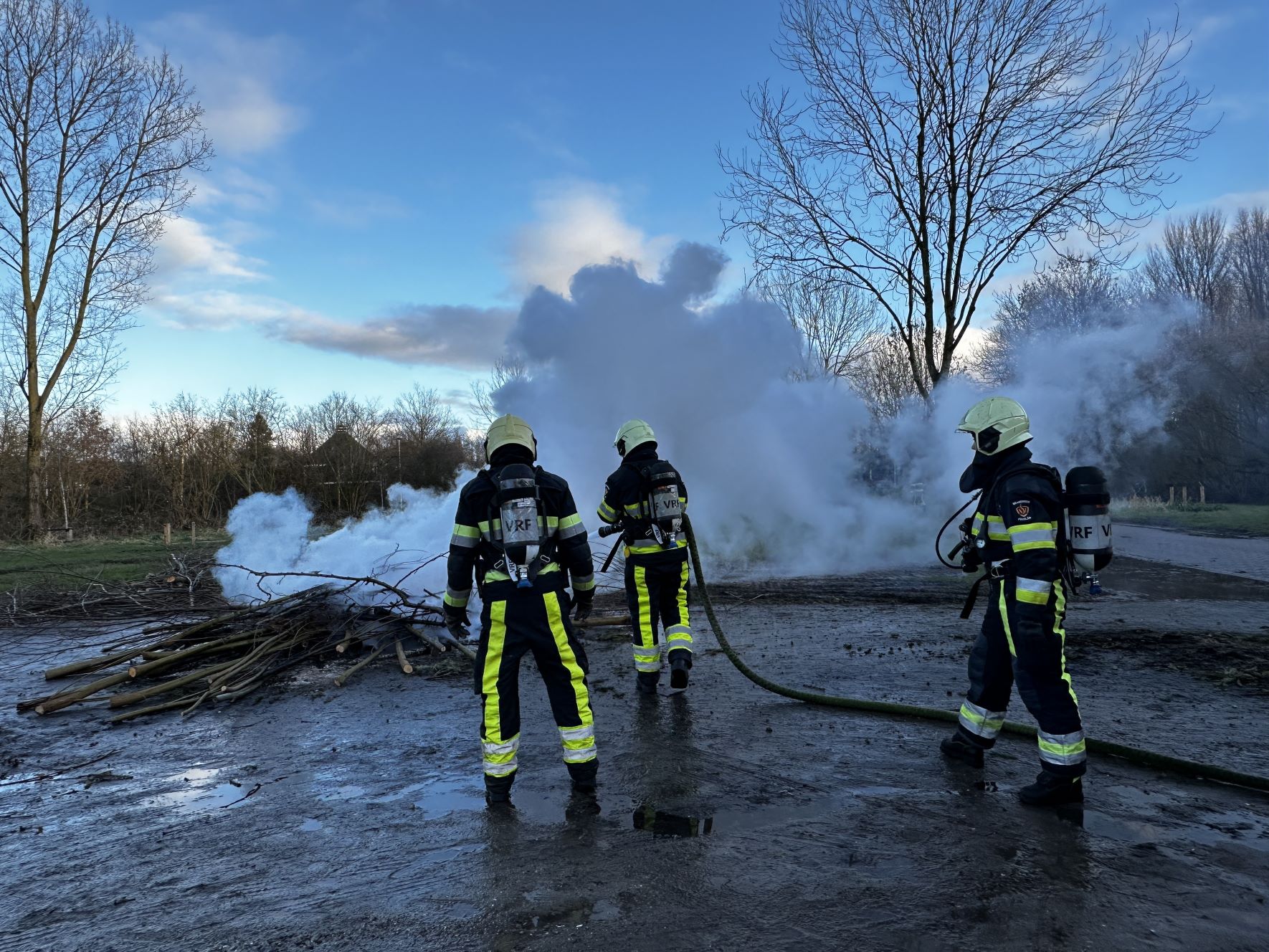Brandweer blust brand in een berg takken te Leeuwarden