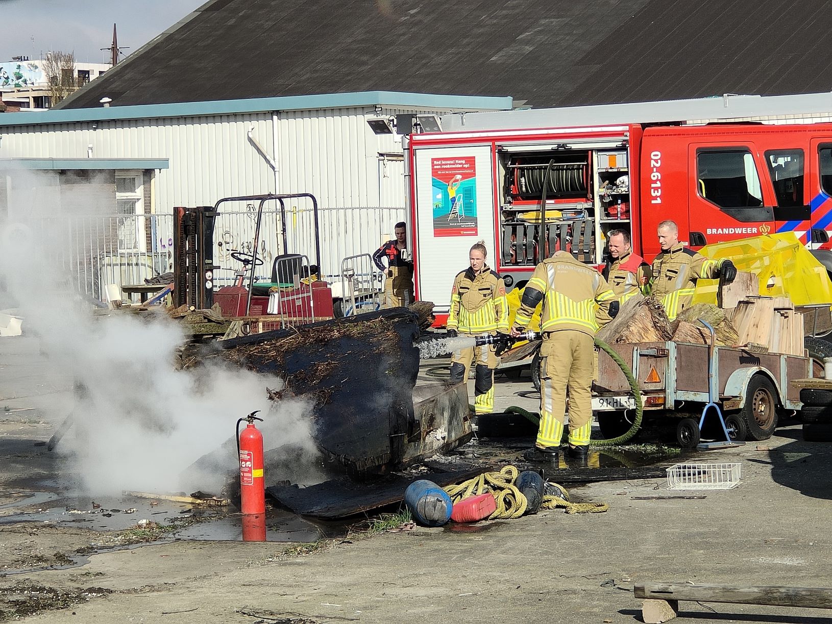 Brandweer blust brandende stapel hout in Leeuwarden