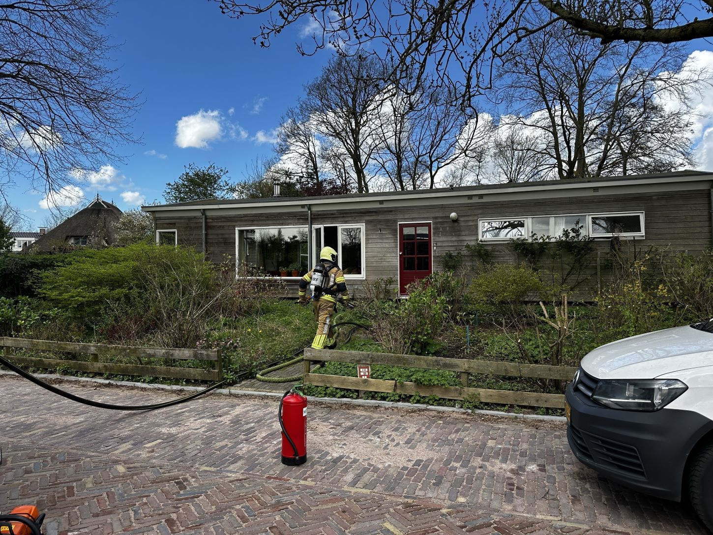 Brandweer blust brand achter woning in Snakkerburen