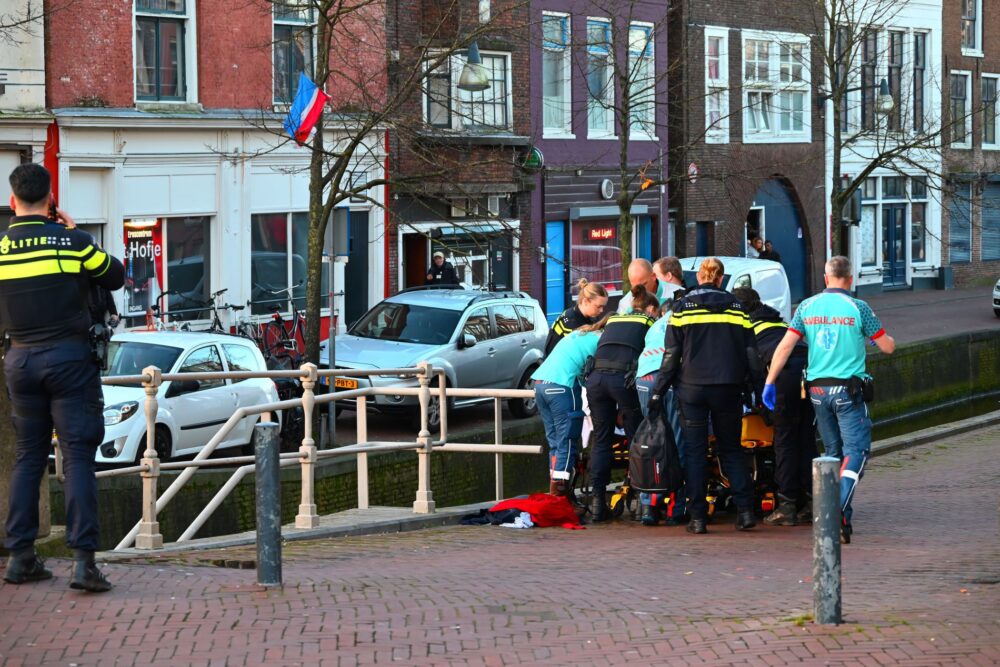 Omstander haalt persoon uit het water op de Weaze in Leeuwarden