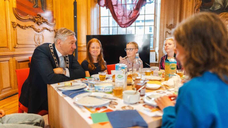Schoolkinderen eten broodje gezond met burgemeester Buma