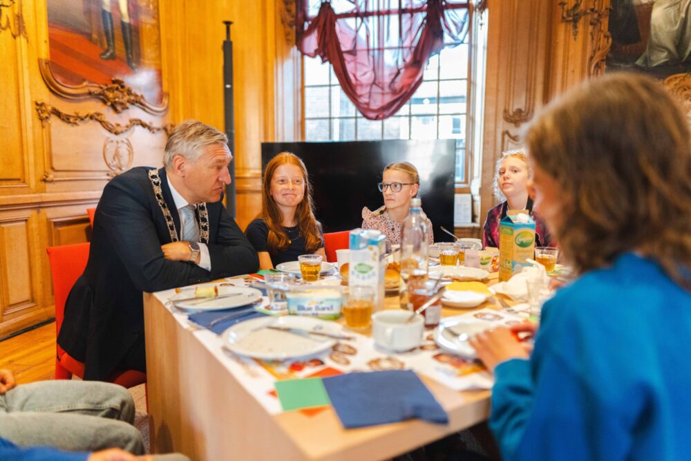 Schoolkinderen eten broodje gezond met burgemeester Buma